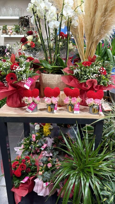 Vitrine de Saint-Valentin – Artisan fleuriste Openflor Rayon de fleurs de Saint-Valentin avec petits bouquets de roses roses surmontés d'un cœur rouge chez Openflor Lille.