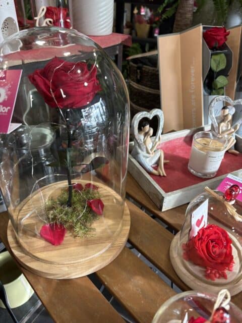 Rose éternelle sous cloche et décor romantique – Openflor Rose éternelle rouge lumineuse sous cloche avec statuettes de couples amoureux en fond, Openflor Lille.