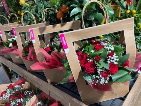 Prêt-à-offrir : Bouquets de roses rouges – Openflor Alignement de sacs cadeaux en kraft contenant des bouquets de roses rouges et gypsophile, Openflor Lille.