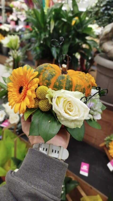Composition Florale Automnale sur Coloquinte – Fleuriste Lille Arrangement floral dans une petite courge décorative avec gerbera orange, rose blanche et baies jaunes, Openflor Lille.