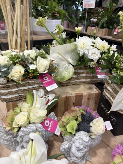 Jardinières de Fleurs Blanches et Anges de Deuil – Openflor Lille Jardinières en vannerie avec roses blanches et anthuriums, accompagnées de statuettes d'anges fleuries, fleuriste Openflor Lille.
