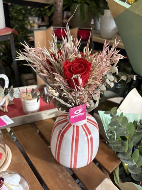 Vase Design et Rose Éternelle Rouge – Déco Saint-Valentin Lille Vase blanc à rayures rouges avec rose éternelle, épis de blé et eucalyptus - Décoration Saint-Valentin Lille.