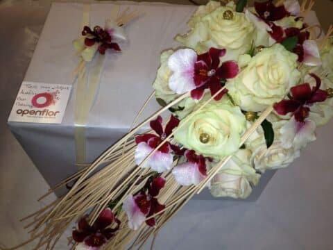Bouquet de mariée allongé – Roses blanches et orchidées Bouquet de mariée allongé avec roses blanches lumineuses et orchidées bordeaux, création florale Openflor Lille.