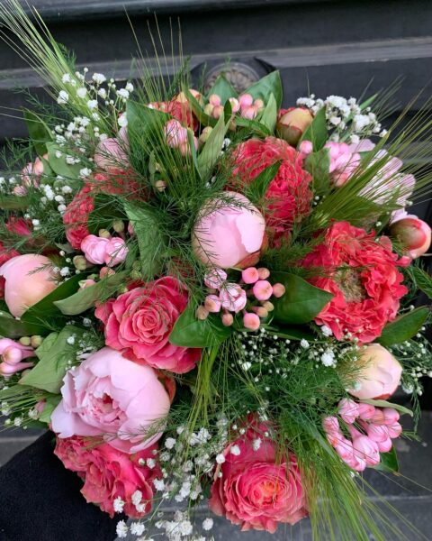Bouquet de pivoines roses et feuillage champêtre Bouquet généreux de pivoines roses en boutons et écloses avec hypericum et feuillage, fleuriste Openflor Lille.