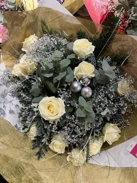 Bouquet féérique d’hiver – Roses blanches et teintes argentées Bouquet d'hiver élégant avec roses blanches, feuillage argenté et boules de Noël, Openflor.
