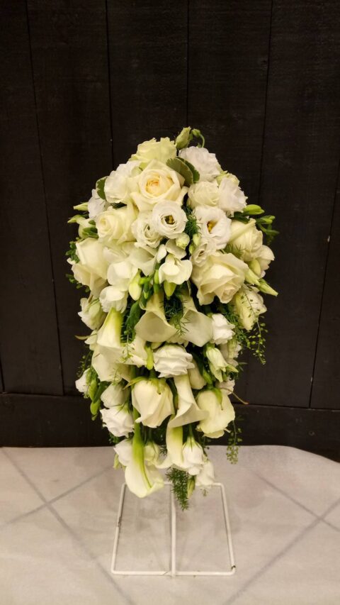 Bouquet de mariée en cascade – Roses et Arums blancs Bouquet de mariée en cascade composé de roses blanches, d'arums et de lisianthus, création Openflor Lille.