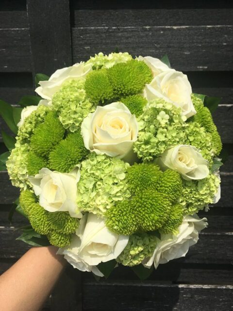 Bouquet de mariée rond – Roses blanches et touches de vert Bouquet de mariée rond très graphique avec roses blanches et fleurs vertes texturées, création mariage Openflor Lille.