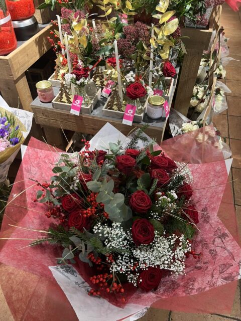 Bouquet de Noël traditionnel – Roses rouges et Ilex Bouquet de Noël traditionnel avec roses rouges, branches d'ilex et gypsophile, Openflor Lille.