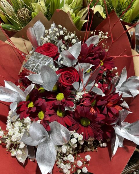 Bouquet de fêtes rouge et argent – Roses et feuillage étincelant Bouquet de fêtes rouge et argent avec roses rouges, feuillage argenté et petit cadeau décoratif, Openflor.