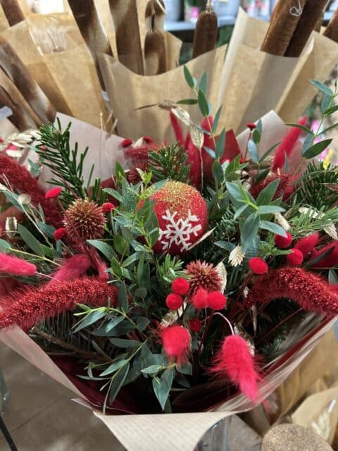 Bouquet de Noël rouge passion – Boule flocon et lagurus Bouquet de Noël rouge texturé avec boule flocon, sapin et lagurus rouge, Openflor Lille.
