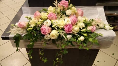 Centre de table allongé pour mariage – Roses pastel et lierre Centre de table de mariage allongé avec roses pastel, lierre et fleurs blanches, Openflor Lille.
