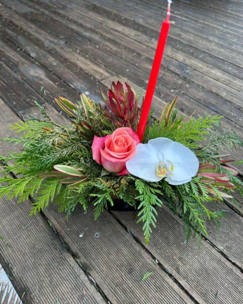 Centre de table de Noël – Bougie rouge, rose et orchidée Centre de table de Noël avec bougie rouge, rose saumon, orchidée blanche et feuillage, Openflor Lille.