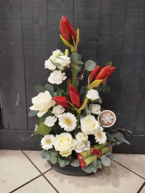 Composition haute de Noël – Amaryllis rouges et roses blanches Grande composition florale de Noël avec amaryllis rouges, roses blanches et feuillage, Openflor.