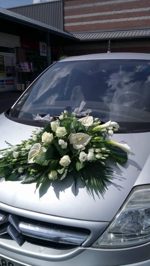 Décoration de voiture de mariage – Anthuriums et arums blancs Composition florale asymétrique pour voiture de mariage avec anthuriums et arums blancs, Openflor Lille.
