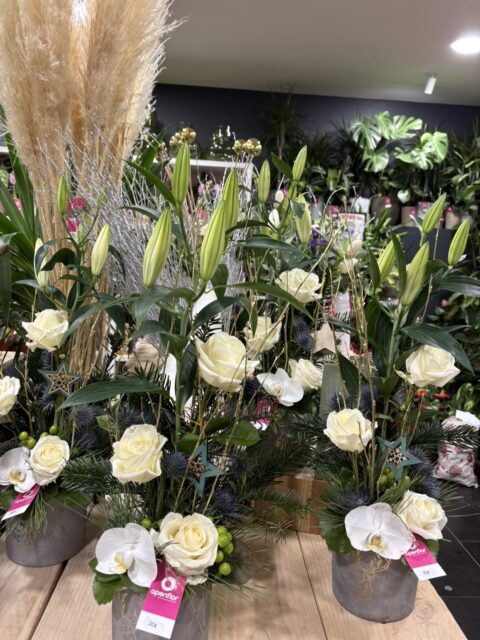 Compositions majestueuses de Noël – Lys blancs, roses et orchidées Compositions de Noël en hauteur avec lys blancs, orchidées, roses et étoiles décoratives, Openflor Lille.