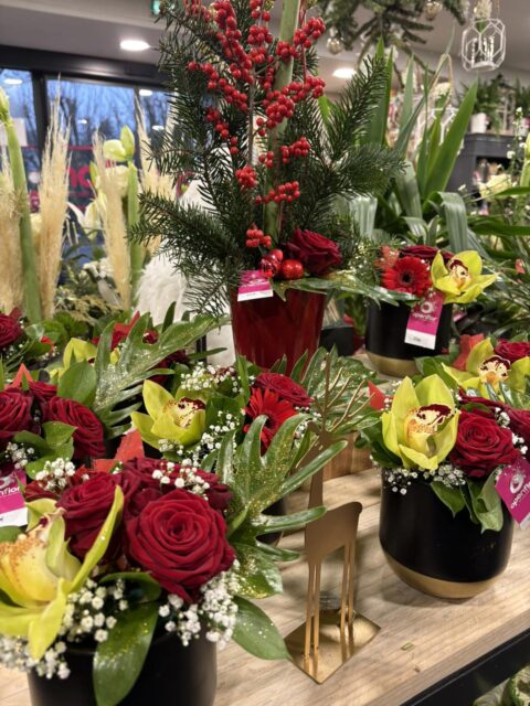 Composition élégante du Nouvel An – Roses rouges et Orchidées Composition de fêtes avec roses rouges, orchidées cymbidium vertes et branchages argentés, Openflor Lille.