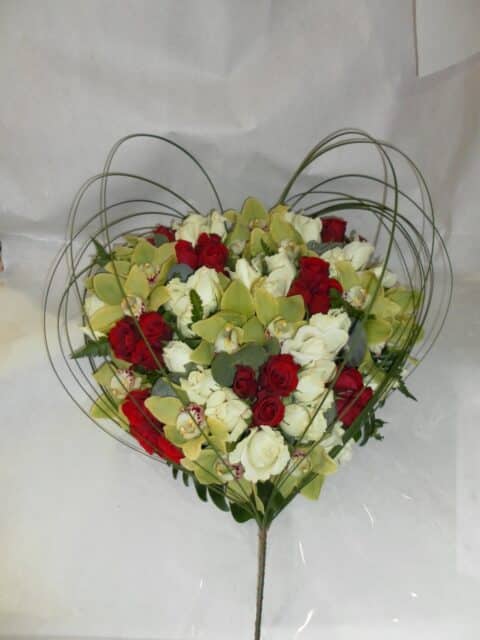 Coussin cœur de mariage – Roses rouges et orchidées Coussin en forme de cœur pour mariage avec roses rouges, blanches et orchidées cymbidium vertes, Openflor.