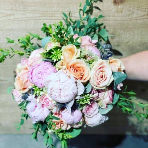 Bouquet de mariée romantique – Pivoines, roses pêche et chardons Bouquet de mariée romantique avec pivoines roses, roses pêche et chardons bleus, fleuriste Openflor.