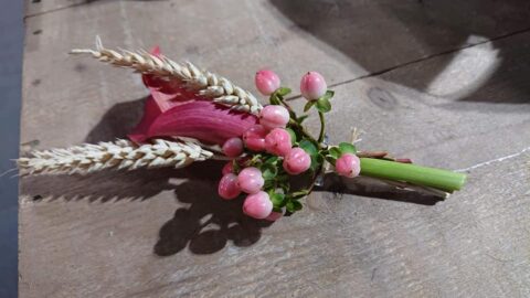 Boutonnière de mariage originale – Arum rouge et blé Boutonnière de mariage originale avec arum rouge, baies roses et épis de blé, artisan Openflor Lille.