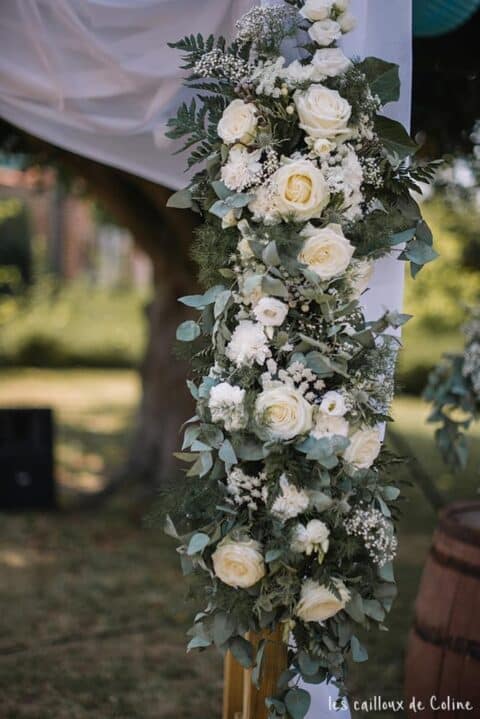 Décoration d’arche de cérémonie – Roses blanches Décoration florale pour arche de cérémonie laïque avec roses blanches et feuillage retombant, Openflor Lille.