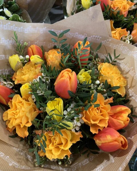 Bouquet tulipes oranges et œillets jaunes – Emballage papier musique Bouquet de fleurs printanières avec tulipes oranges et œillets jaunes emballé dans un papier motif musique, Openflor Lille.