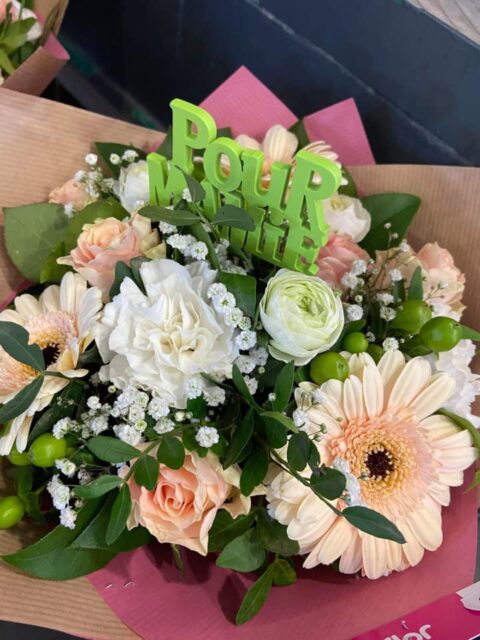 Bouquet pastel pêche avec pic décoratif vert Pour Mamie Bouquet aux teintes pastel pêche avec gerberas et œillets, orné d'un pic décoratif vert Pour Mamie, fleuriste Openflor.