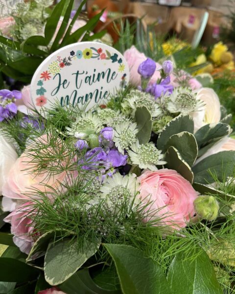 Bouquet renoncules roses pastel – Pancarte Je t’aime Mamie Bouquet de renoncules roses pastel et feuillage avec pancarte Je t'aime Mamie, artisan fleuriste Openflor Lille.