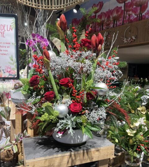 Grande composition de Noël – Amaryllis, roses rouges et argent Grande composition de Noël prestigieuse avec amaryllis, roses rouges et boules argentées, fleuriste Openflor.