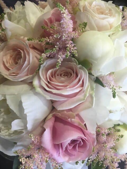 Détail de bouquet de mariée – Roses pastel et astilbe Gros plan sur un bouquet de mariée avec roses pastel, pivoines blanches et astilbe rose, Openflor.