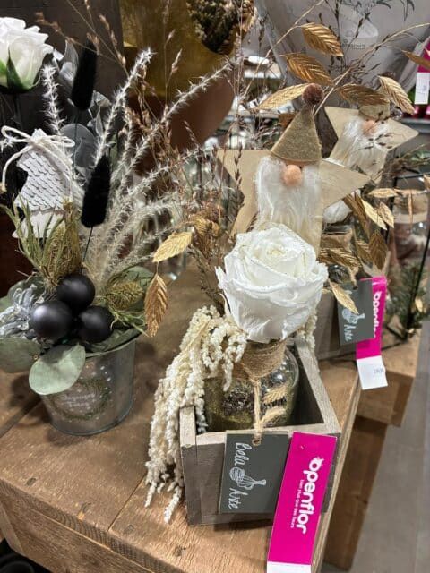 Boîte décorative de Noël – Rose éternelle blanche et or Rose éternelle blanche dans une petite boîte en bois avec feuillage doré et boules noires, décoration de Noël Openflor Lille.