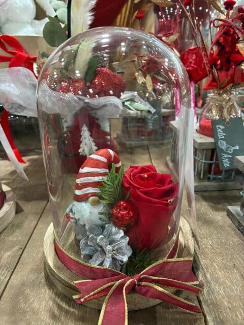 Rose rouge sous cloche – Décoration de Noël avec lutin Rose éternelle rouge sous cloche en verre avec lutin de Noël et pomme de pin, fleuriste Openflor Lille.